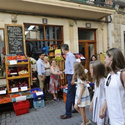 El Rey Felipe saluda a una ciudadana durante un paseo por Soller con la Reina Letizia y sus hijas