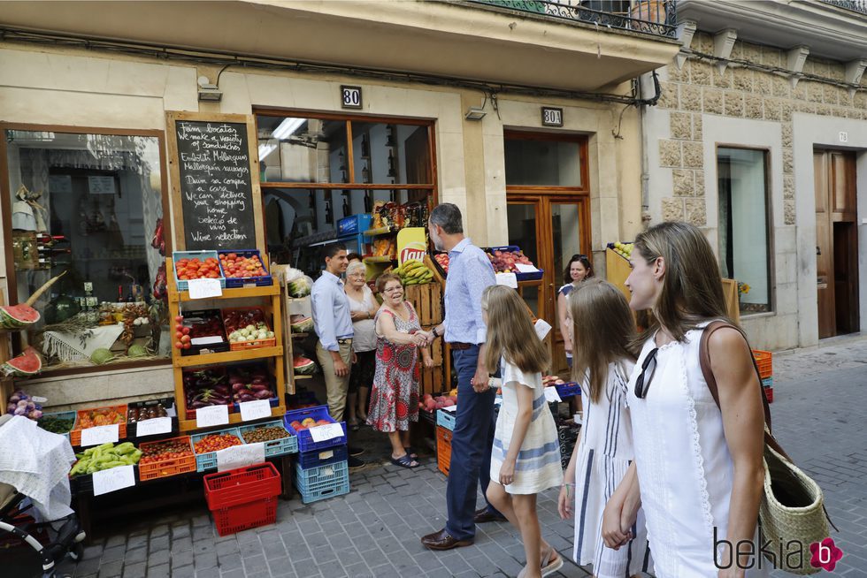 El Rey Felipe saluda a una ciudadana durante un paseo por Soller con la Reina Letizia y sus hijas