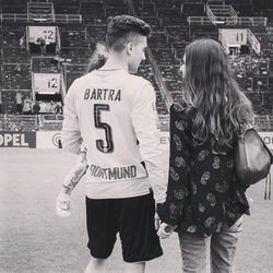 Melissa Jiménez, Marc Bartra y su hija Gala en el campo de fútbol del Betis