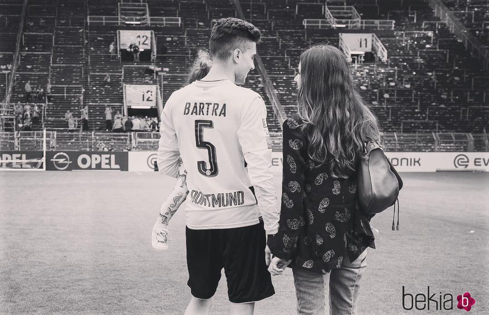 Melissa Jiménez, Marc Bartra y su hija Gala en el campo de fútbol del Betis