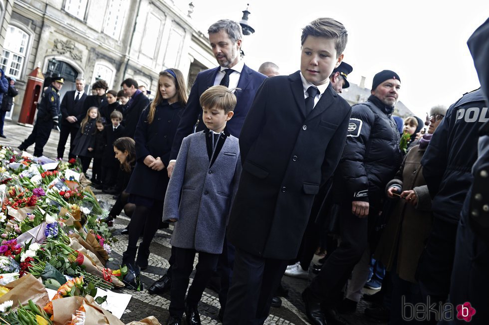 Los hijos, las nueras y los nietos de Enrique de Dinamarca miran los recuerdos colocados en su honor en Amalienborg