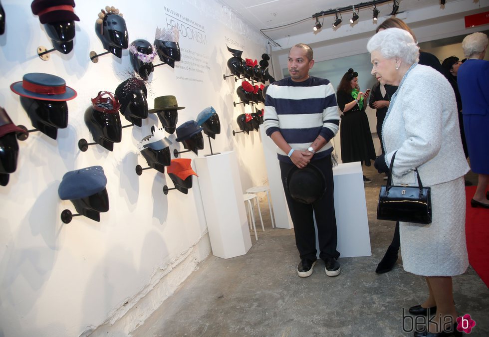 La Reina Isabel mirando sombreros y tocados en la London Fashion Week 2018