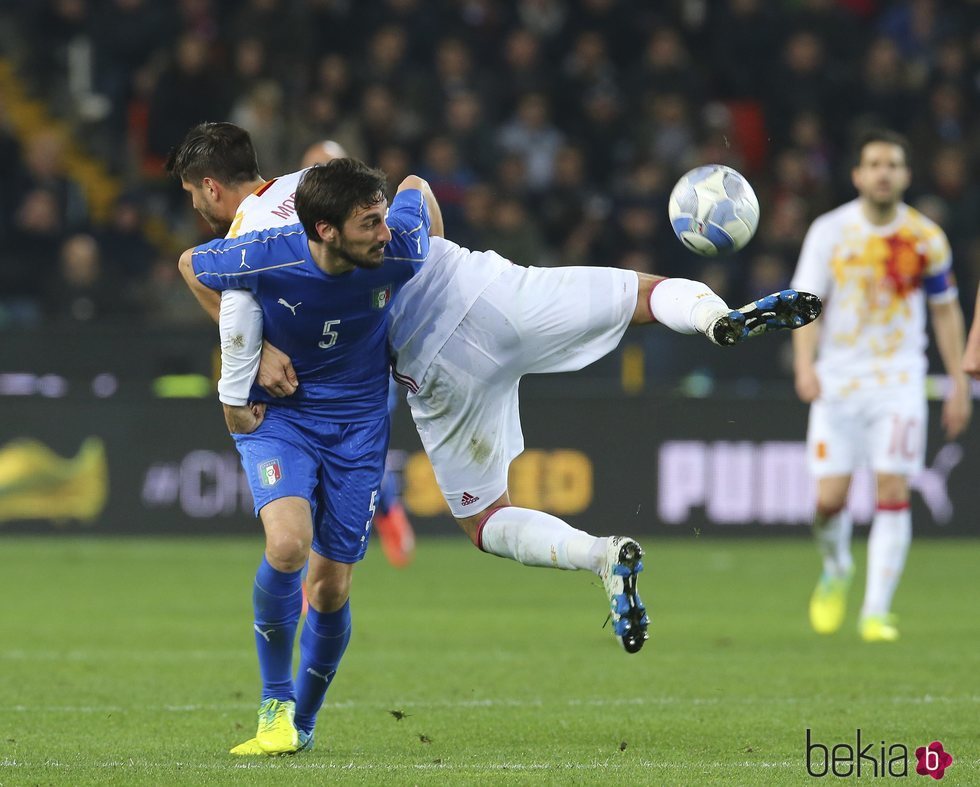 Davide Astori agarra a Álvaro Morata en un partido contra España