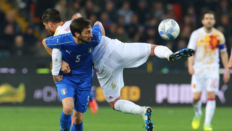 Davide Astori agarra a Álvaro Morata en un partido contra España