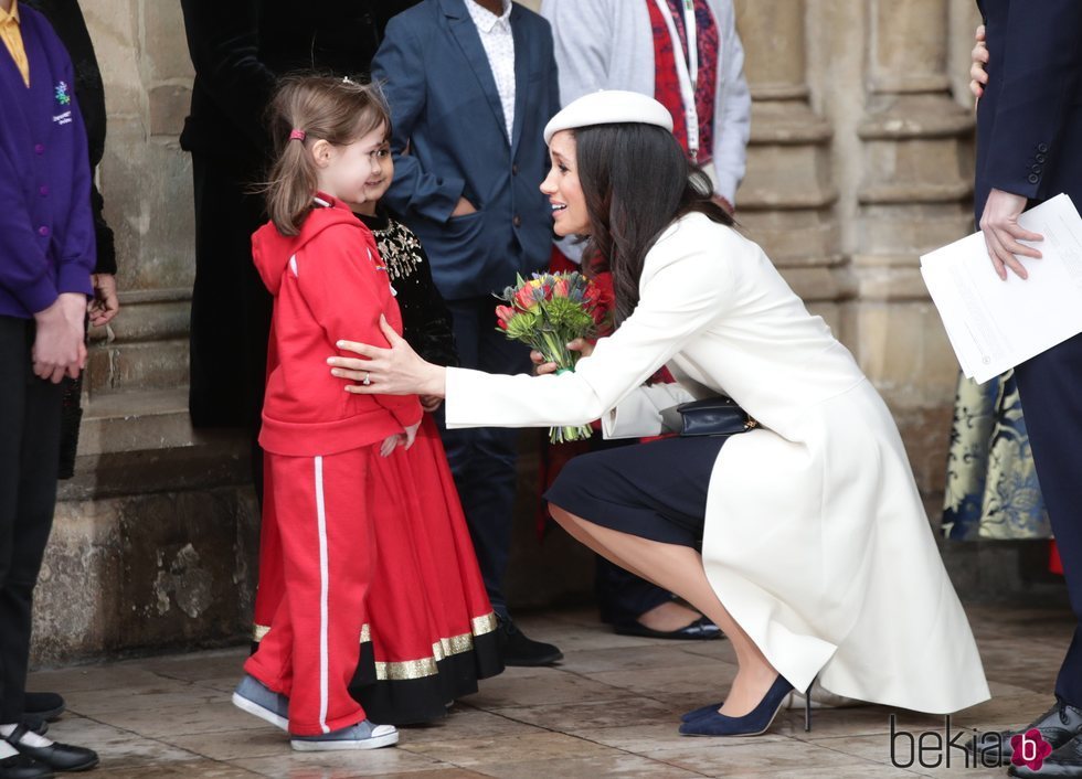 Meghan Markle se agacha para hablar con una niña en el Día de la Commonwealth 2018