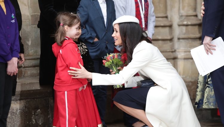 Meghan Markle se agacha para hablar con una niña en el Día de la Commonwealth 2018