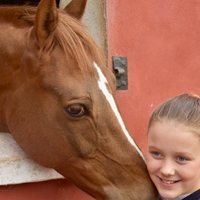 Isabel de Dinamarca feliz junto a un caballo en su onceavo cumpleaños