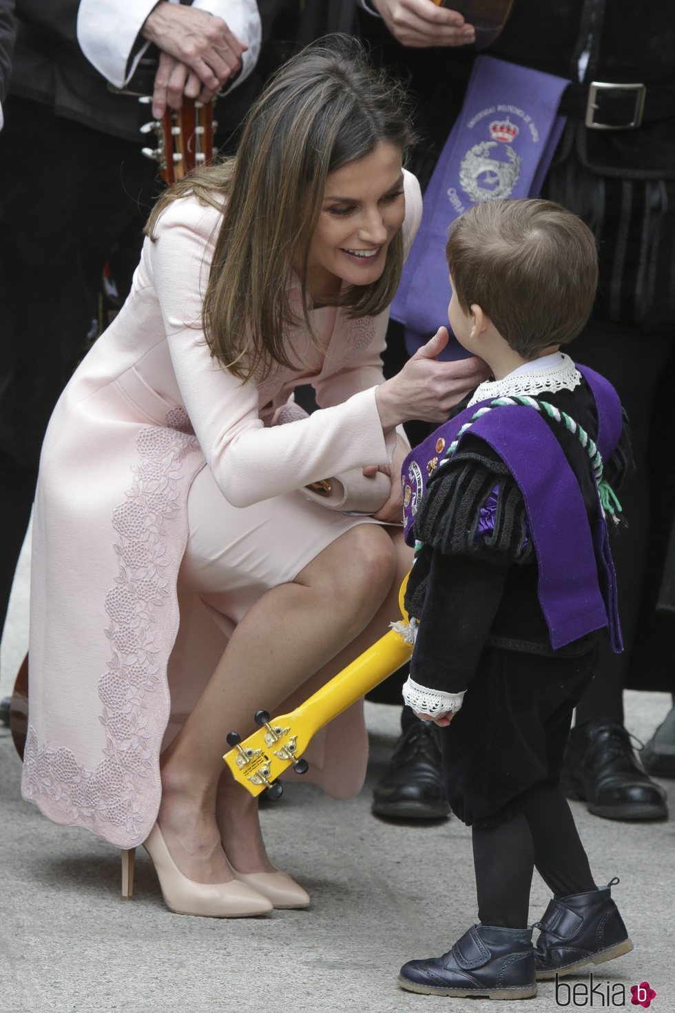 La Reina Letizia hablando con un niño pequeño tras la ceremonia del Premio Cervantes 2017