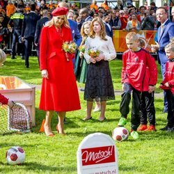 La Reina Máxima de Holanda junto a sus hijas presenciando un acto deportivo