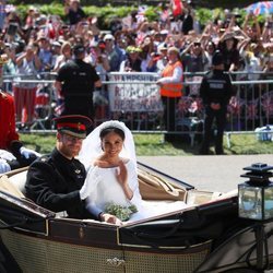 El Príncipe Harry de Inglaterra y Meghan Markle saludando desde el carruaje