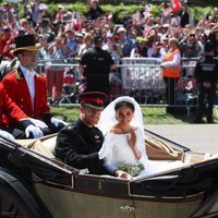 El Príncipe Harry de Inglaterra y Meghan Markle saludando desde el carruaje