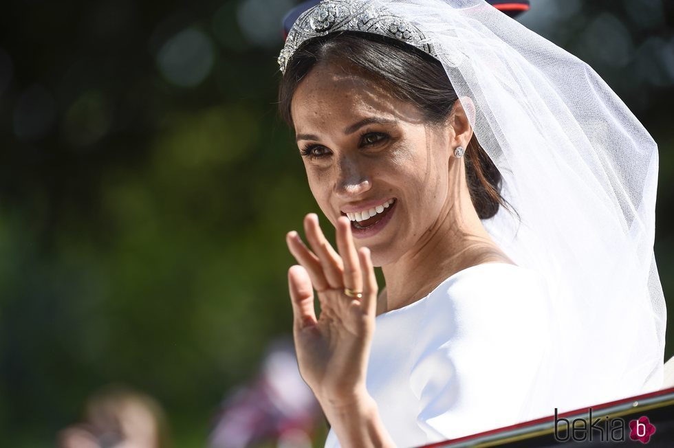 Meghan Markle saluda sonriente desde el carruaje