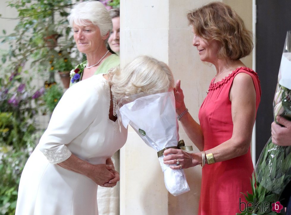 Camilla Parker oliendo un ramo de flores en el Garden Museum