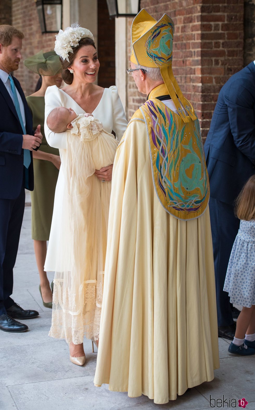 Kate Middleton saluda al Arzobispo de Canterbury con su hijo Luis en brazos en el bautizo del Príncipe Luis