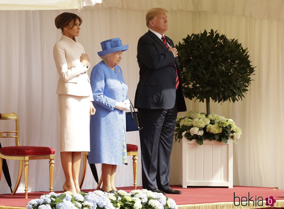 Los Trump con la mano en el corazón junto a la Reina Isabel II