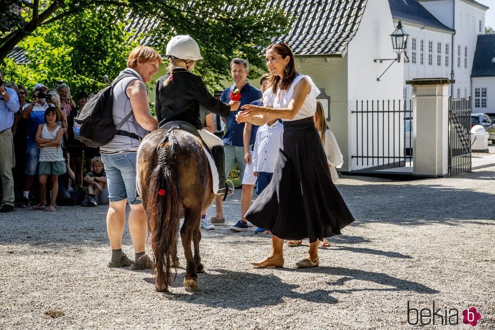 La Princesa Mary de Dinamarca junto a una de las jinetes del tradicional desfile de verano en el Palacio de Grasten