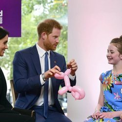 El Príncipe Harry y Meghan Markle con una niña en los Premios WellChild