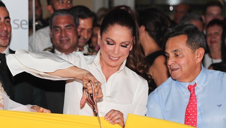 Isabel Pantoja cortando la banda en la inauguración de un evento publicitario