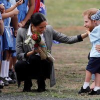 Meghan Markle ríe divertida mientras un niño toca la barba del Príncipe Harry