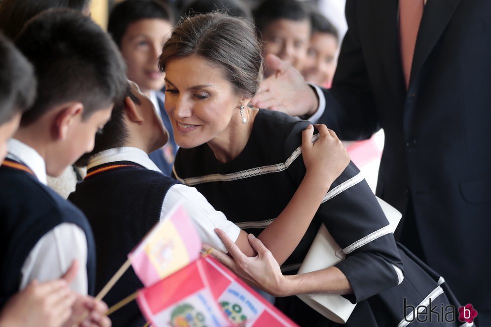 La Reina Letizia, muy cariñosa con un niño del colegio Reino de España de Lima