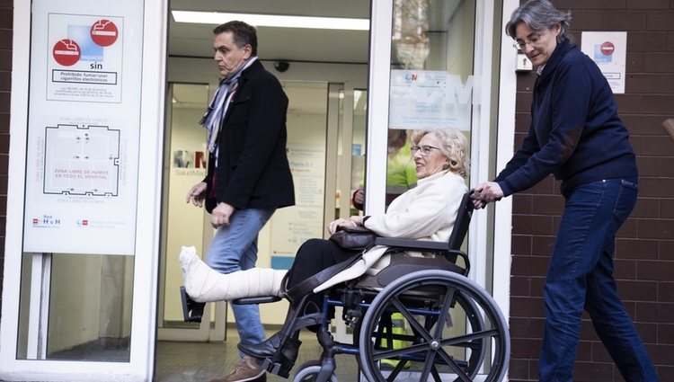 Manuela Carmena en silla de ruedas saliendo del hospital