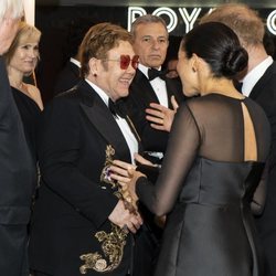 El Príncipe Harry y Meghan Markle saludando a Elton John en el estreno de 'El Rey León' en Londres