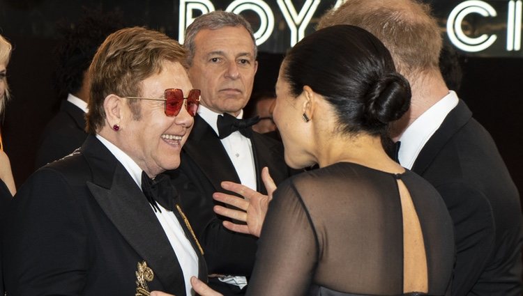 El Príncipe Harry y Meghan Markle saludando a Elton John en el estreno de 'El Rey León' en Londres