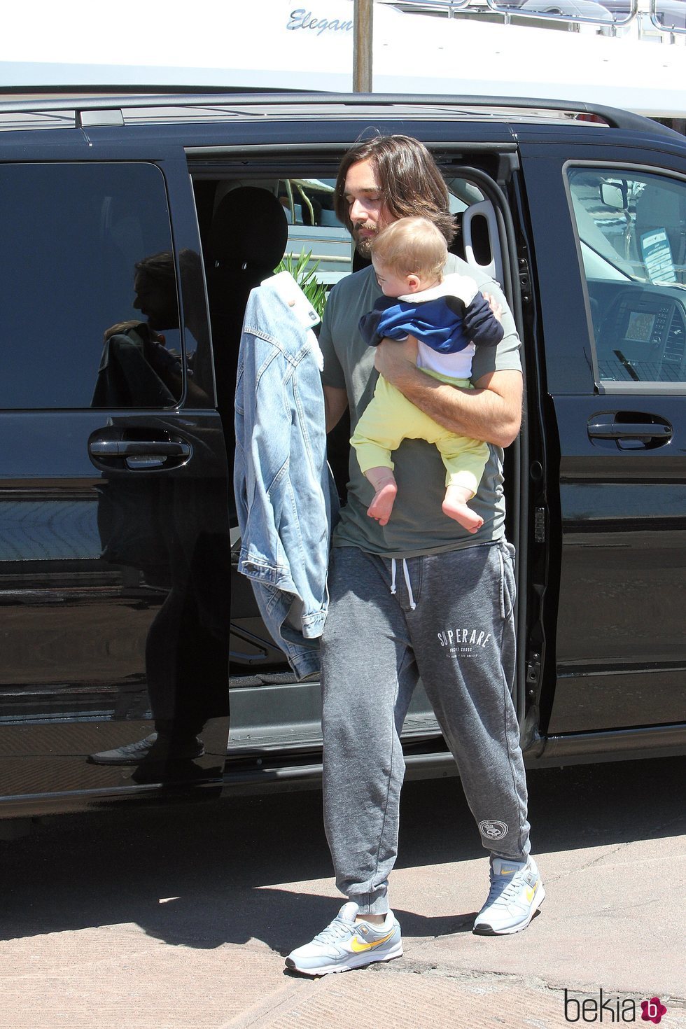 Dimitri Rassam con su hijo Balthazar en brazos llegando al puerto de Nápoles