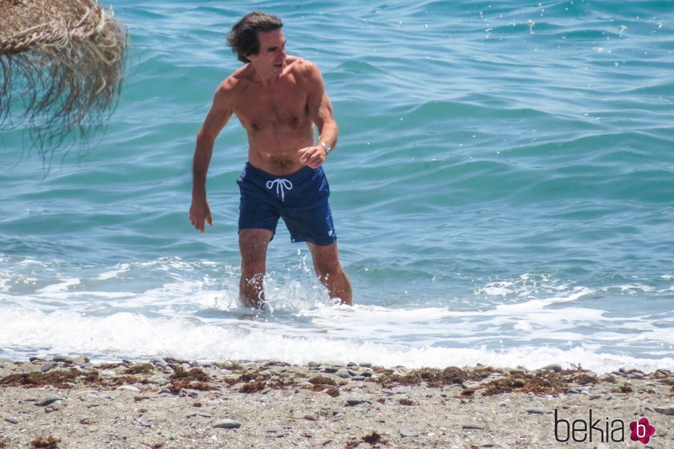 José María Aznar con el torso desnudo saliendo del mar