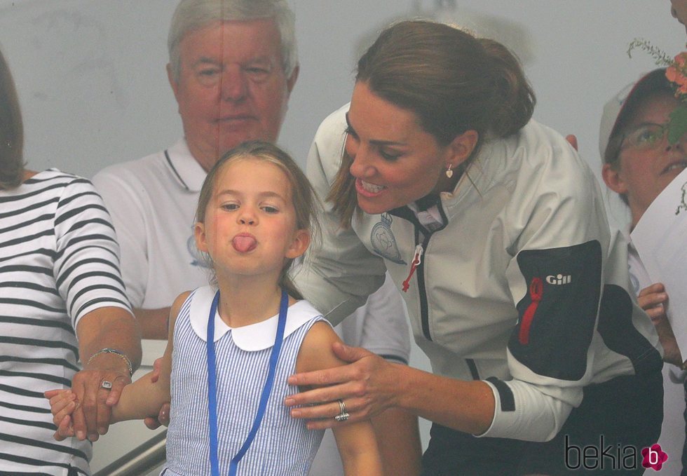 La Princesa Carlota sacando la lengua ante la mirada risueña de su madre