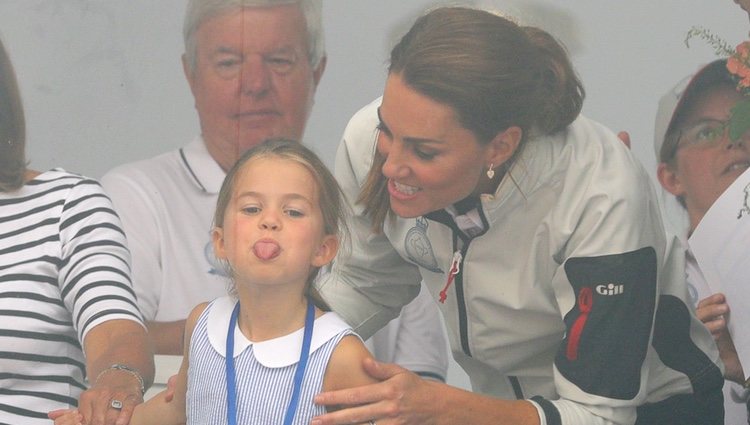 La Princesa Carlota sacando la lengua ante la mirada risueña de su madre