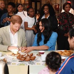 Meghan Markle y el Príncipe Harry, comiendo dulces en un centro de acogida en Ciudad del Cabo