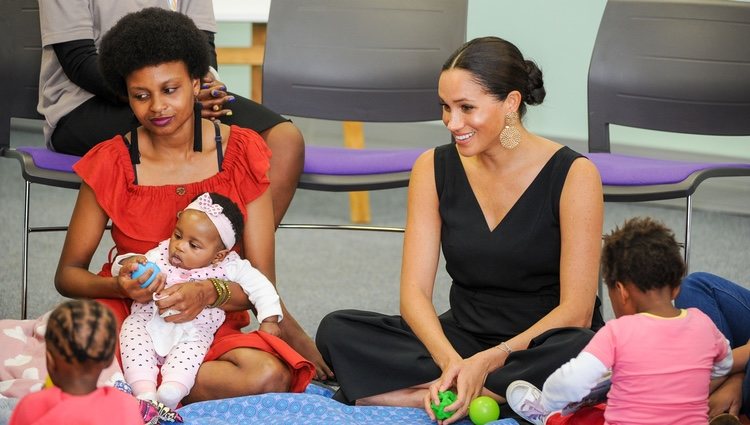 Meghan Markle con una mujer y unas niñas en su visita a Mothers 2 Mothers en Sudáfrica