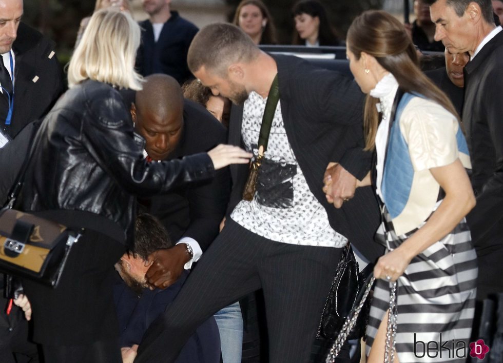 Un hombre agarrándose a la pierna de Justin Timberlake a su llegada al desfile de Louis Vuitton en París