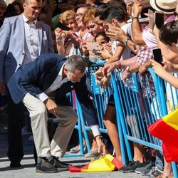 El Rey Felipe VI recogiendo una bandera de España del suelo en la visita a Orihuela