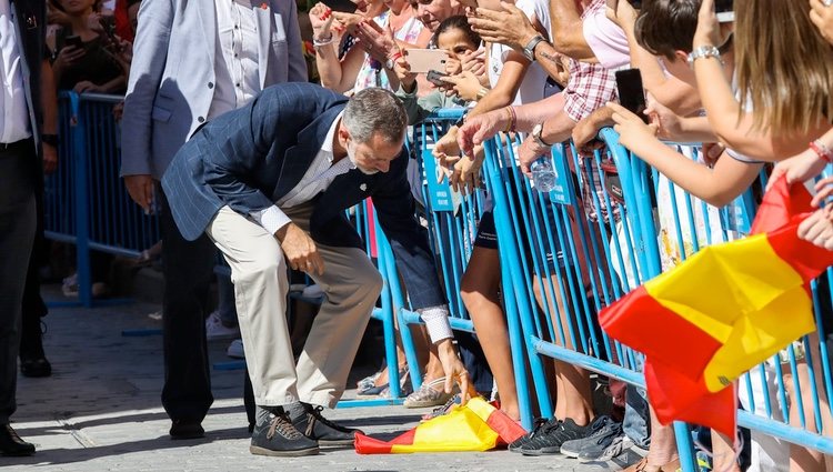 El Rey Felipe VI recogiendo una bandera de España del suelo en la visita a Orihuela