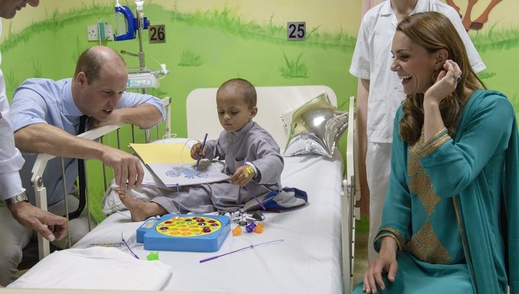 Los Duques de Cambridge jugando con un niño en un hospital infantil en Pakistán