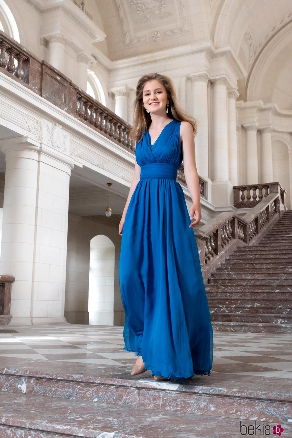 Isabel de Bélgica con un vestido azul en las escaleras de Laeken