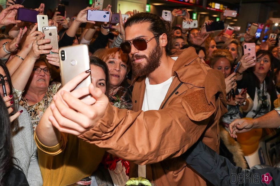 Can Yaman haciéndose una foto con una fan a su llegada a España