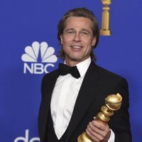 Brad Pitt posando con su premio en los Globos de Oro 2020