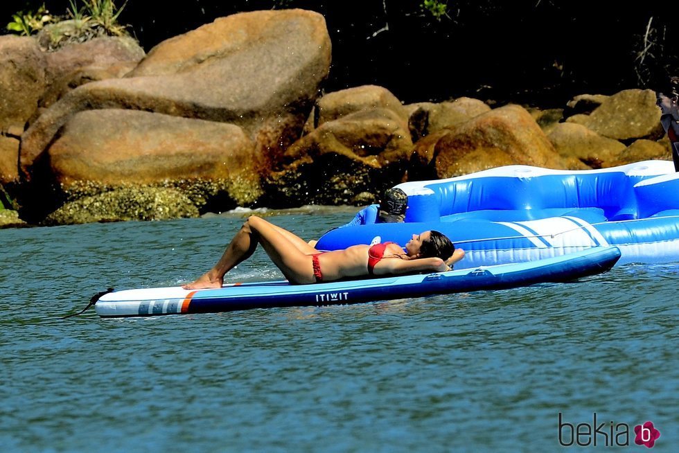 Alessandra Ambrosio tomando el sol en una tabla de surf