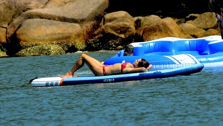 Alessandra Ambrosio tomando el sol en una tabla de surf