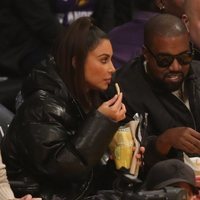 Kim Kardashian y Kanye West comiendo en un partido de baloncesto