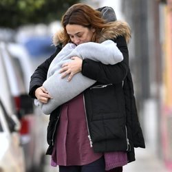 Toñi Moreno dando un beso a su hija Lola mientras pasea con ella en brazos