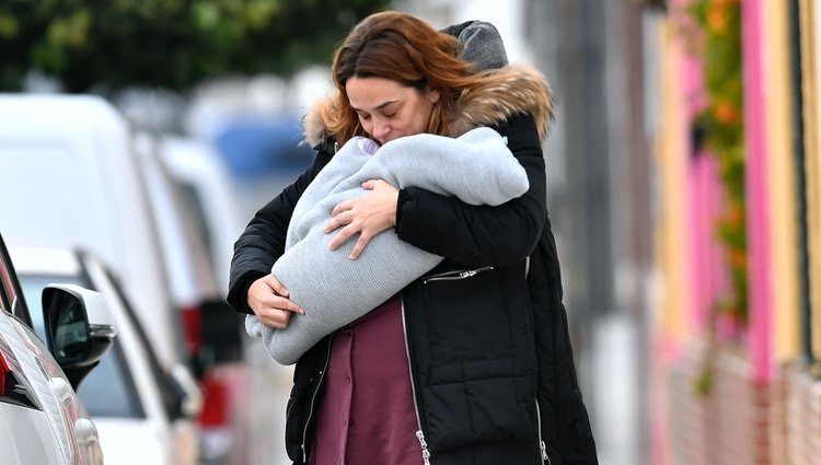 Toñi Moreno dando un beso a su hija Lola mientras pasea con ella en brazos