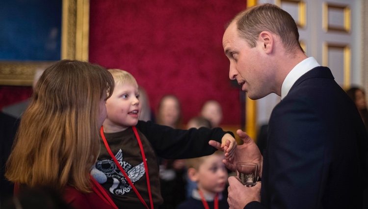 El Príncipe Guillermo con un niño en una recepción en St James Palace