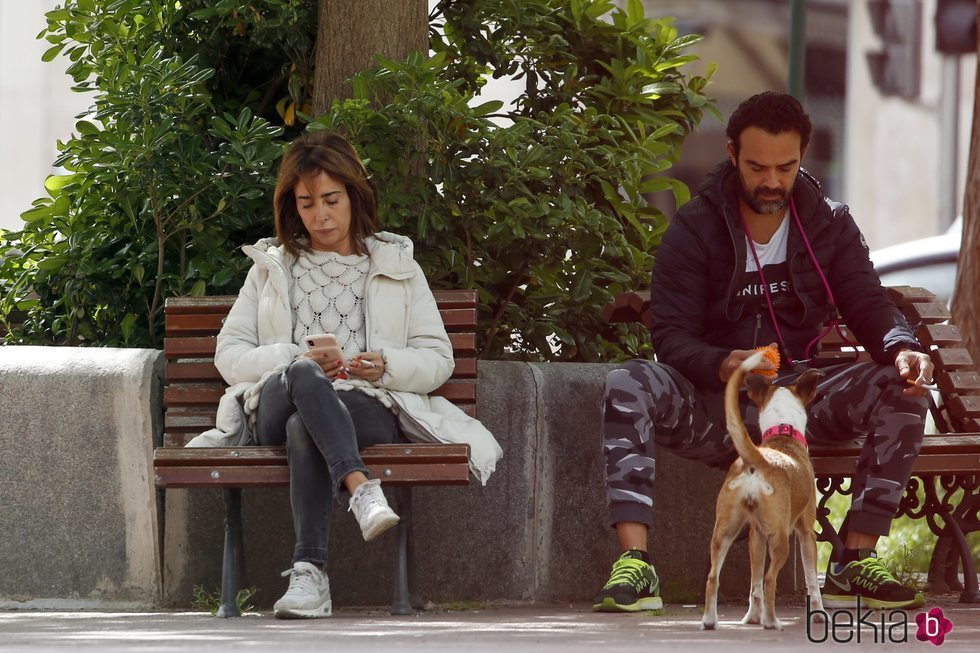 María Patiño mira el móvil mientras Ricardo Rodríguez Olivares juega con su perra