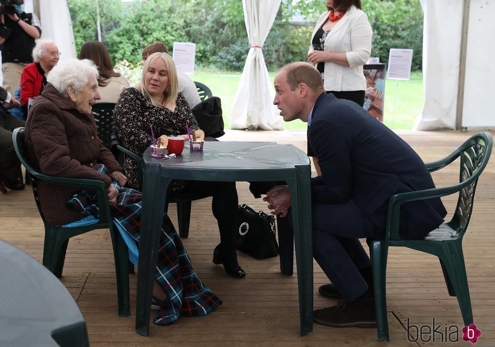 El Príncipe Guillermo con una anciana y su nieta en una residencia de ancianos de Edimburgo