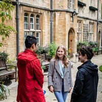 Isabel de Bélgica habla con dos chicos en el Lincoln College Oxford