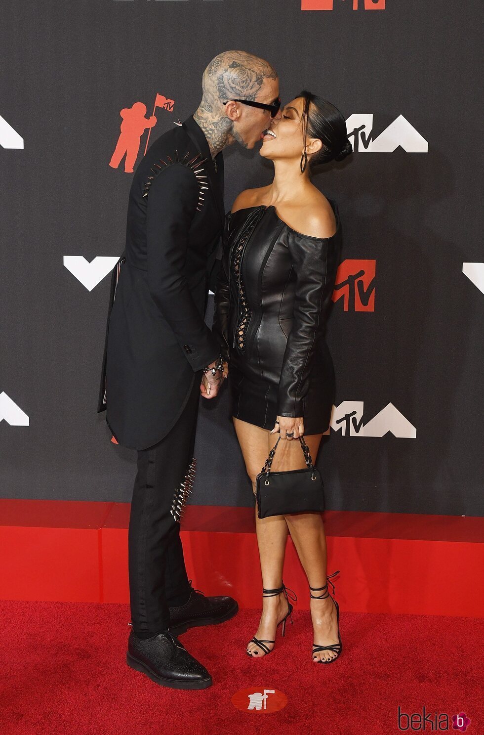 Travis Barker y Kourtney Kardashian besándose en la alfombra roja de los MTV VMAs 2021